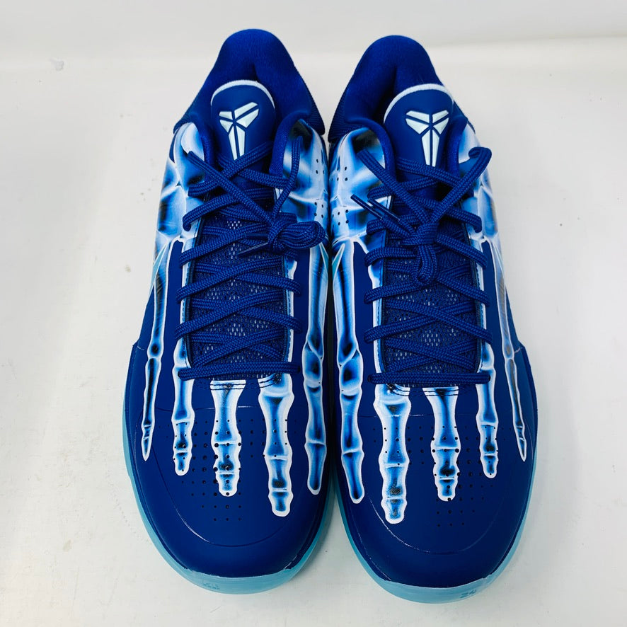 The Nike Kobe 5 Protro X-Ray shoes are blue with a unique white drip pattern on top and feature a white emblem on the tongue. The laces and soles blend with the primary blue color, and they are displayed side by side on a light surface.