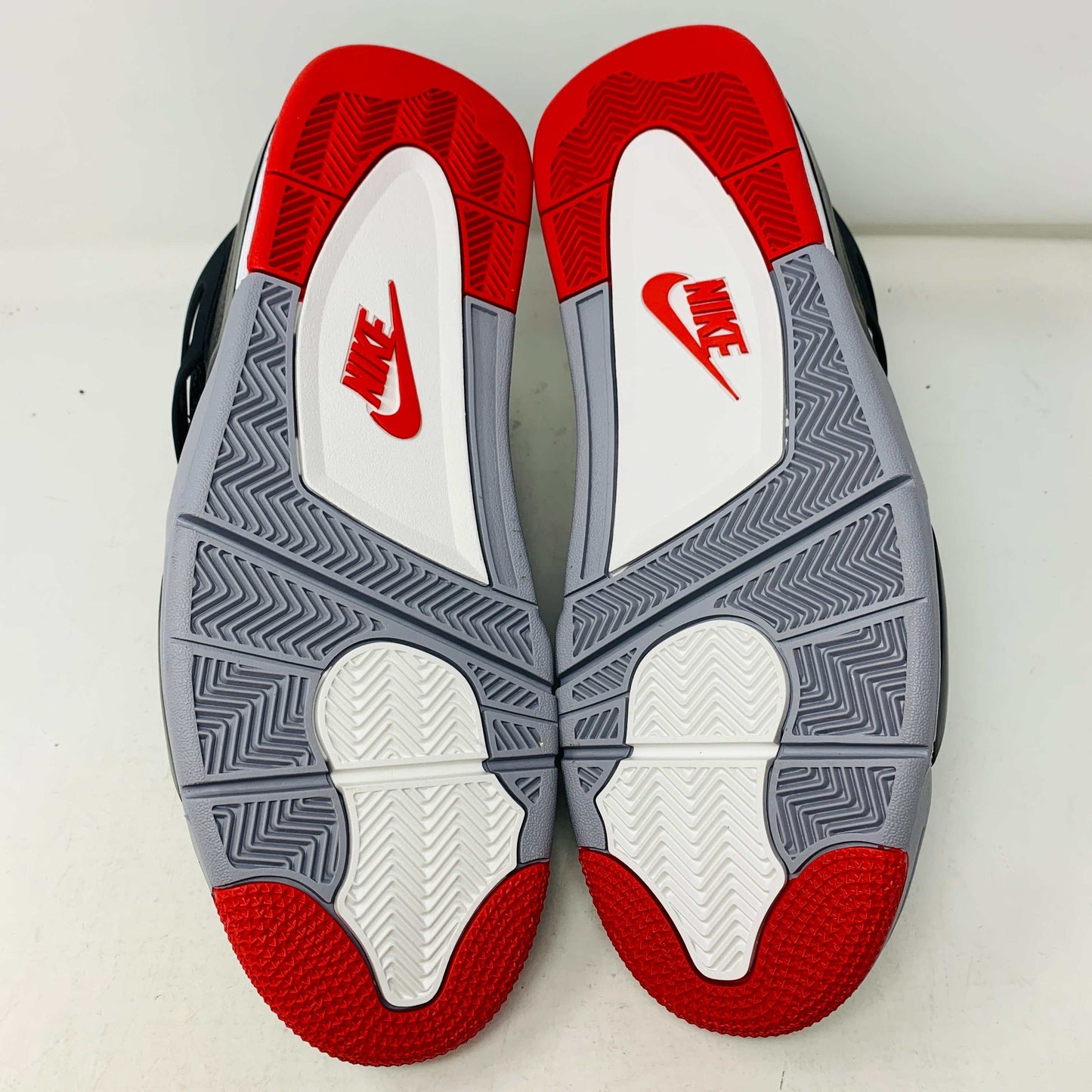 Jordan 4 Retro Bred Reimagined outsole featuring classic red, white, and black colorway with Nike logo.