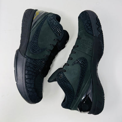 The Nike Kobe 4 Protro Gift of Mamba, a black athletic shoe with clean uppers and a reptile-like texture, is shown on its box. It features the iconic swoosh and a visible Zoom Air unit in the heel. The box label includes shoe size and product details.