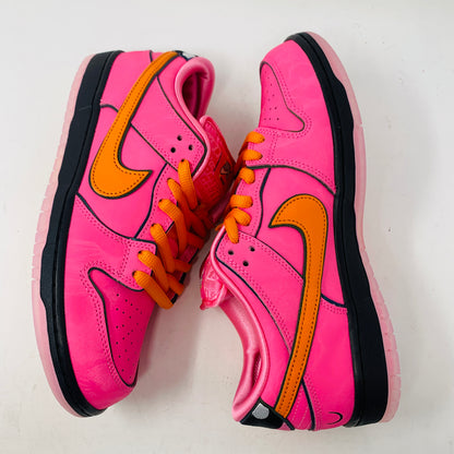 The Nike SB Dunk Low The Powerpuff Girls Blossom features vibrant pink with orange swooshes and laces, plus dark pink soles and black accents. They embody Blossoms bold style standing side by side on a white background.