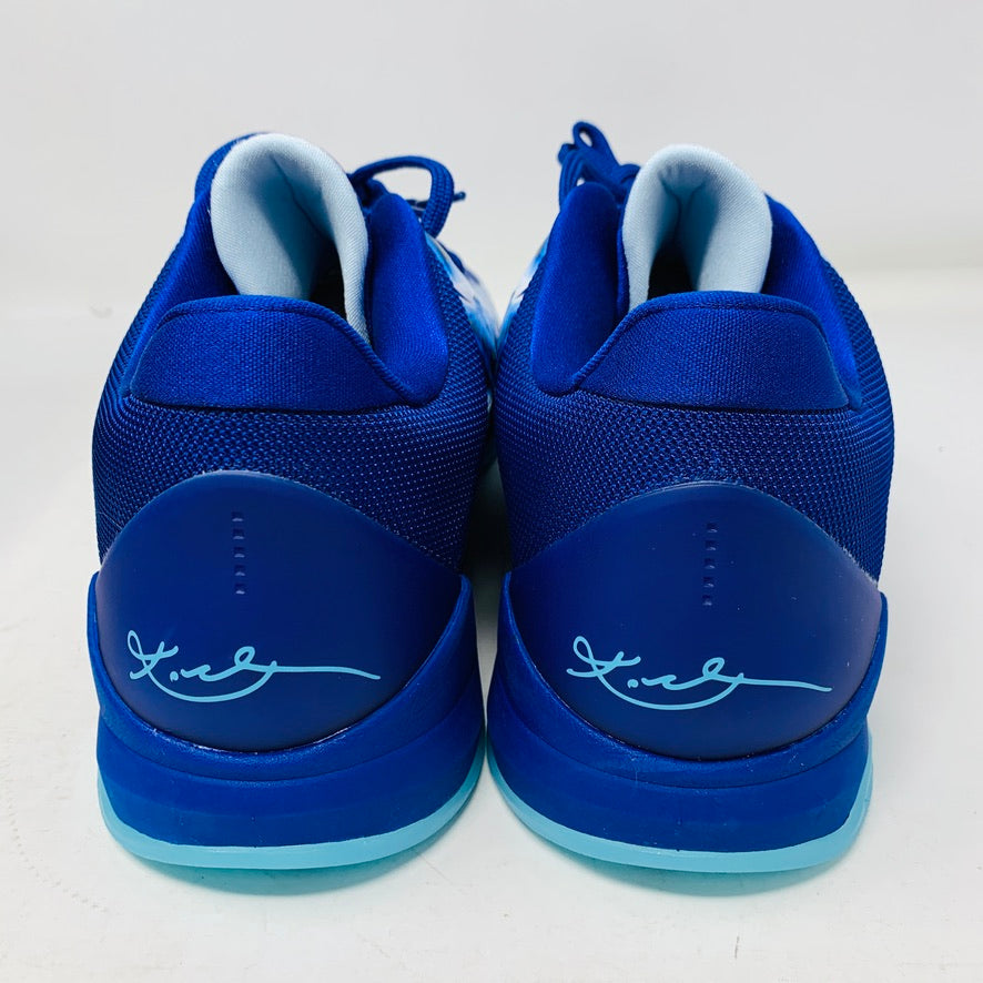 Back view of Nike Kobe 5 Protro X-Ray sneakers in blue with white accents and a cursive signature on the heels, featuring a rubber sole in a contrasting blue shade.