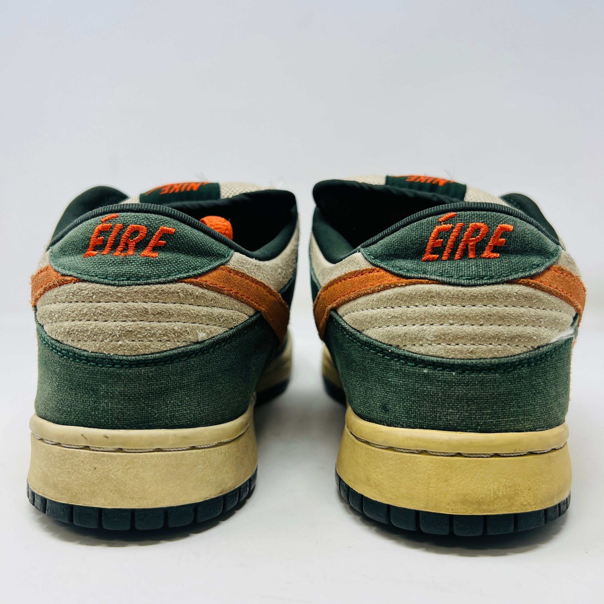 The Nike SB Dunk Low Eire by Holy Ground features a green and beige colorway with an orange swoosh and logo detail on the heel. It comes with a black box, extra Nike laces, ensuring authenticity and versatility.