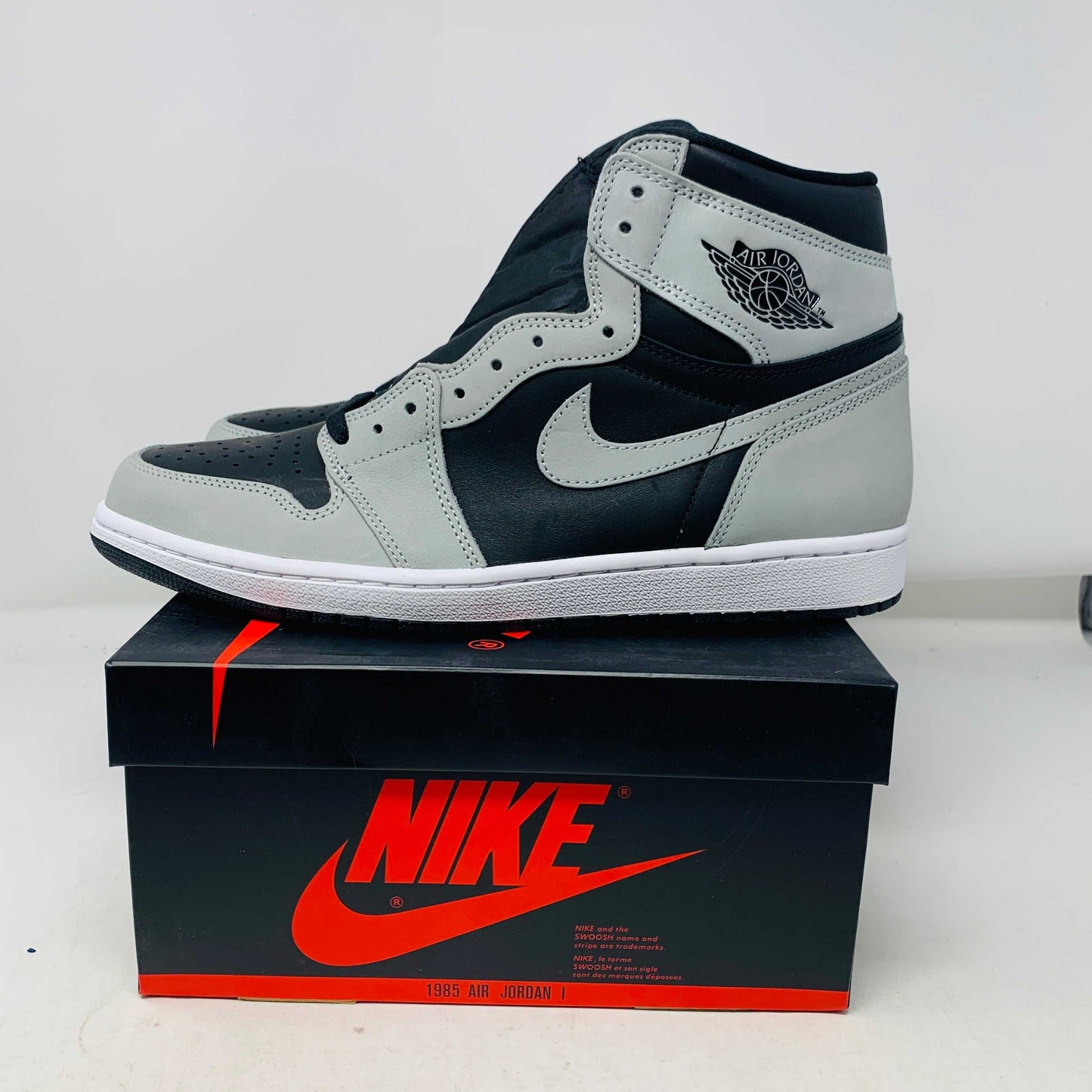 Jordan 1 Shadow 2.0 sneakers in black and grey on Nike box.