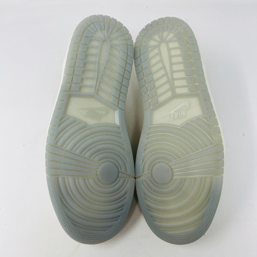 The image showcases the soles of a pair of translucent Jordan 1 Retro Low OG Year of the Dragon (2024) shoes, with circular tread patterns at the forefront and line patterns. The Jordan logo is visible at the midsection against a plain white background.