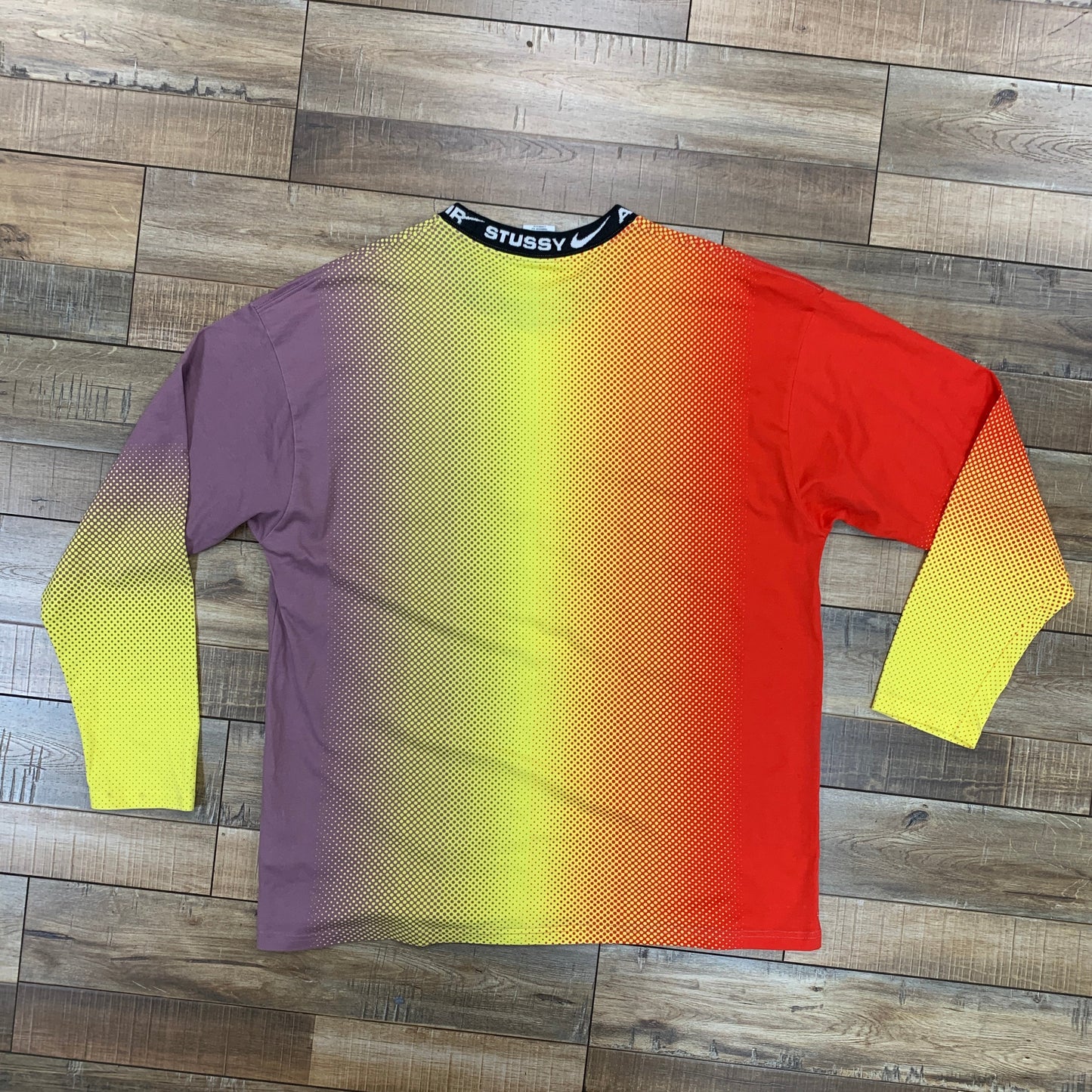 Nike x Stussy L/S T-shirt Multi, size large, preowned, multicolored design on wooden floor.