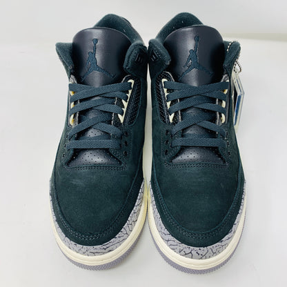 The Jordan 3 Retro Off Noir (W) sneakers feature a dark green and black colorway with a white and gray patterned sole, distinct jumpman logo on the tongue, and are crafted from a mix of leather and suede materials.