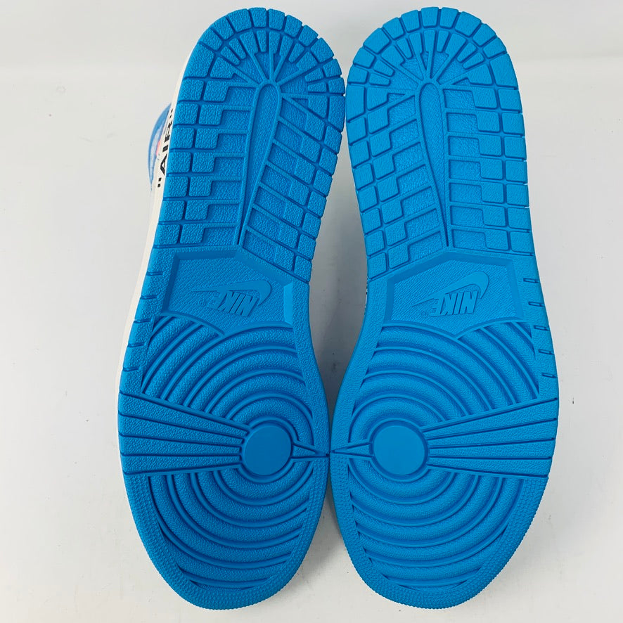 A pair of Jordan 1 Retro High Off-White University Blue sneaker soles is displayed on a light surface, showcasing tread patterns with grooves and circular designs. The word Jordan is visible in the center of each sole.