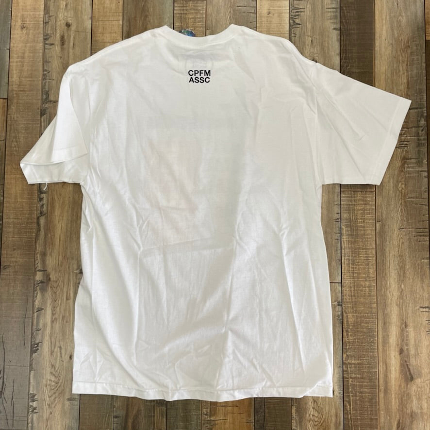 A slightly wrinkled Anti Social Social Club x CPFM Foreshadow Logo Shirt, from the brand CPFM, is laid flat on a wooden floor, featuring small, black CPFM ASSC text printed near the top center of the back.