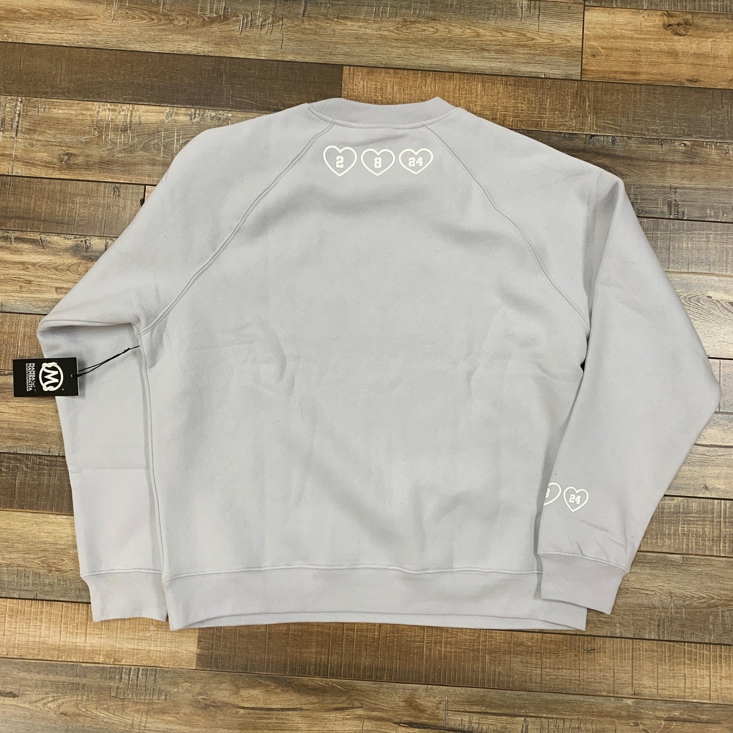 MAMBA ACADEMY Set Grey sweatshirt on wooden floor.