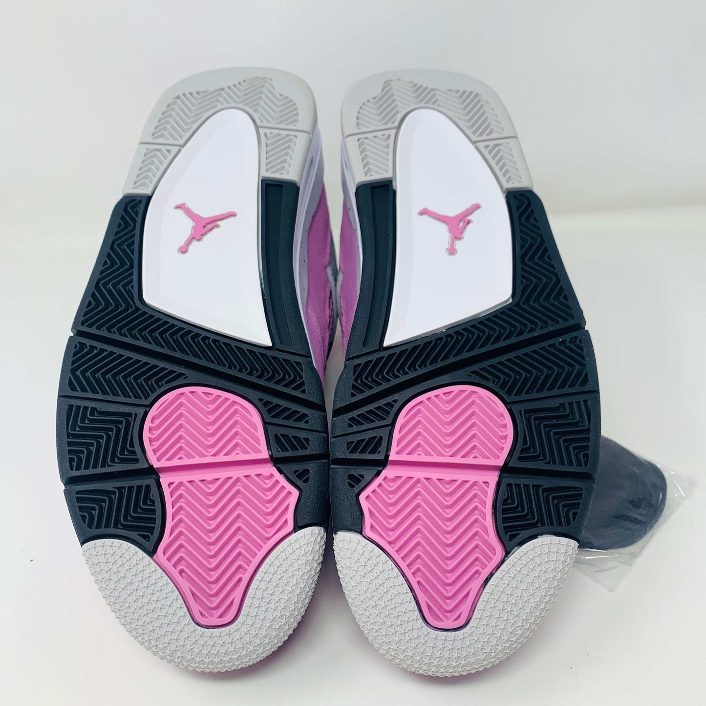 Jordan 4 Retro Orchid Women's sneakers with pink and black sole.