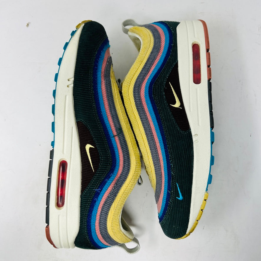 The Nike Air Max 1/97 Sean Wotherspoon sneakers feature a layered design in yellow, blue, pink, and gray with a wave logo on the tongue. These authentic shoes have a textured upper stitched intricately for an eye-catching finish against a white background.