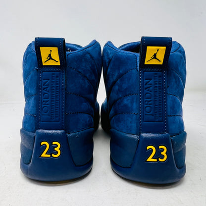 The Jordan 12 Retro Michigan is a blue high-top sneaker with yellow accents from Jordans 2018 Shoes collection. It features a textured surface, stitching details, and a visible Jumpman label. The dark blue sole highlights its vibrant design against a white background.