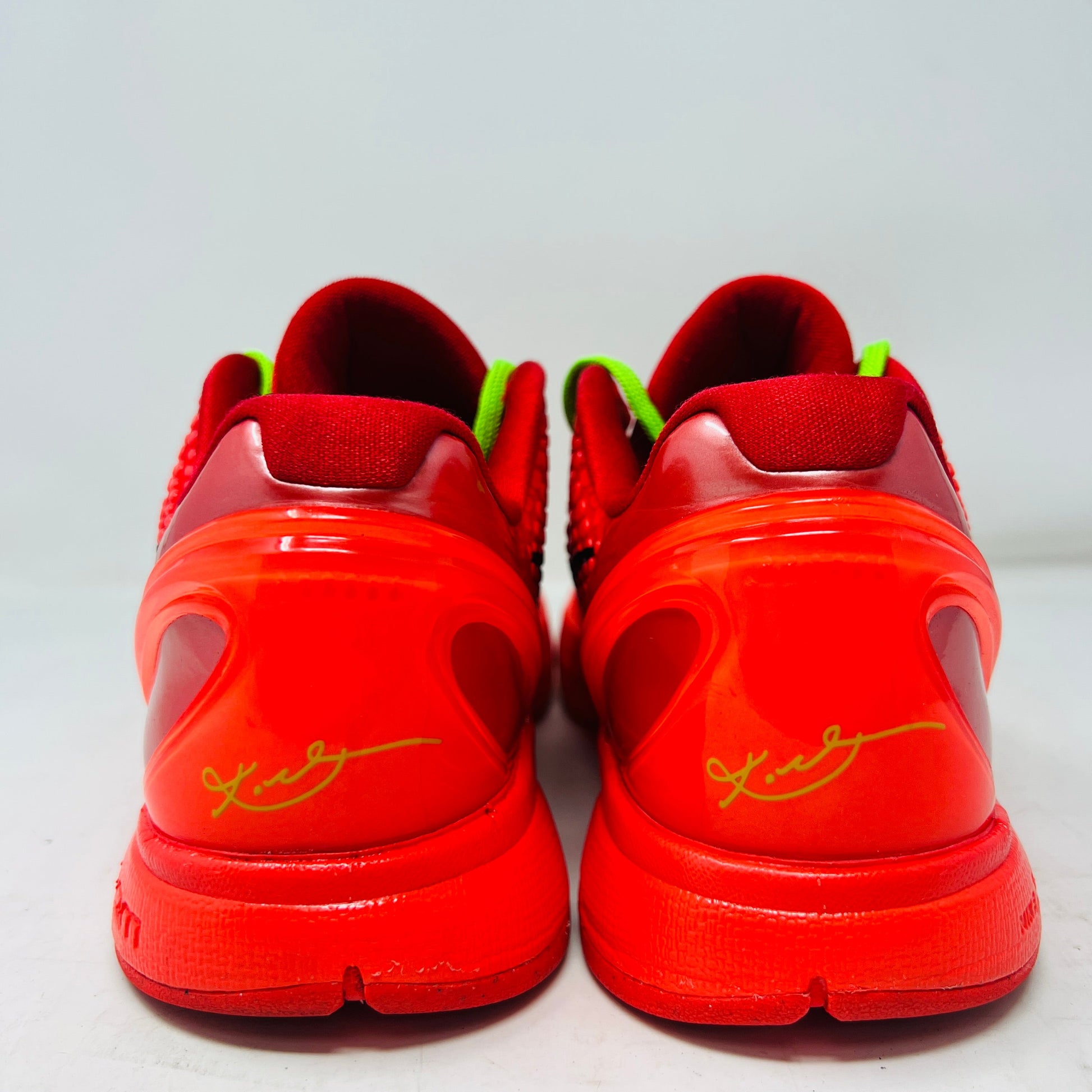 Red Nike Kobe 6 Protro Reverse Grinch sneakers with green accents and signature detail.