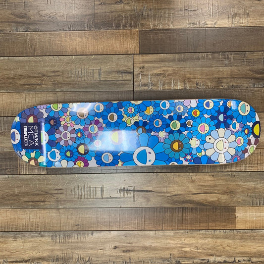 Takashi Murakami Flower Skateboard Deck Blue on wood floor.