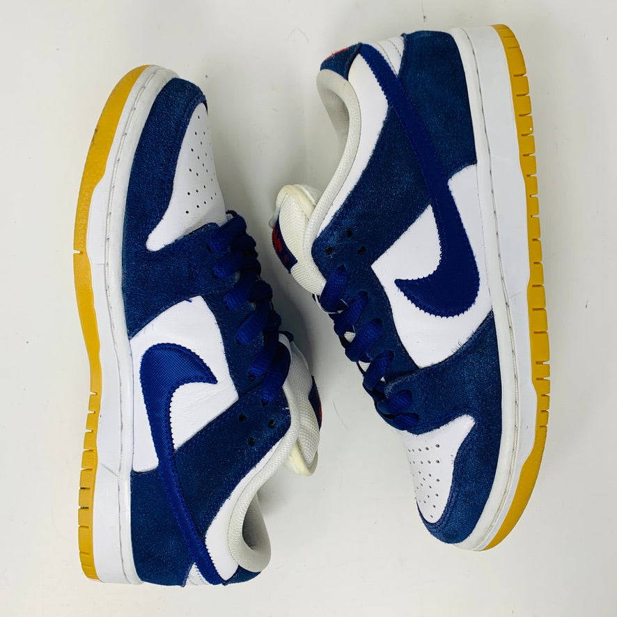 The Nike SB Dunk Low Los Angeles Dodgers sneakers showcase blue suede and white leather panels with a blue logo on the sides. They feature yellow soles and are side by side against a white background.