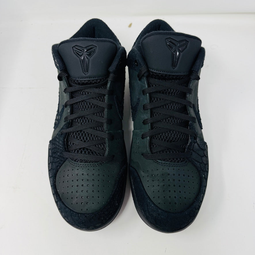 The Nike Kobe 4 Protro Gift of Mamba, a black athletic shoe with clean uppers and a reptile-like texture, is shown on its box. It features the iconic swoosh and a visible Zoom Air unit in the heel. The box label includes shoe size and product details.