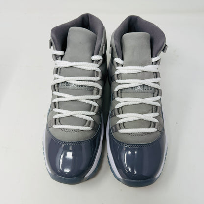 The Jordan 11 Retro Cool Grey (2021) (GS) sneakers by Jordan feature glossy patent leather overlays, a Jumpman logo on the heel, clean white uppers, and laces. They are displayed on a pristine Nike shoebox with size and model details labeled.