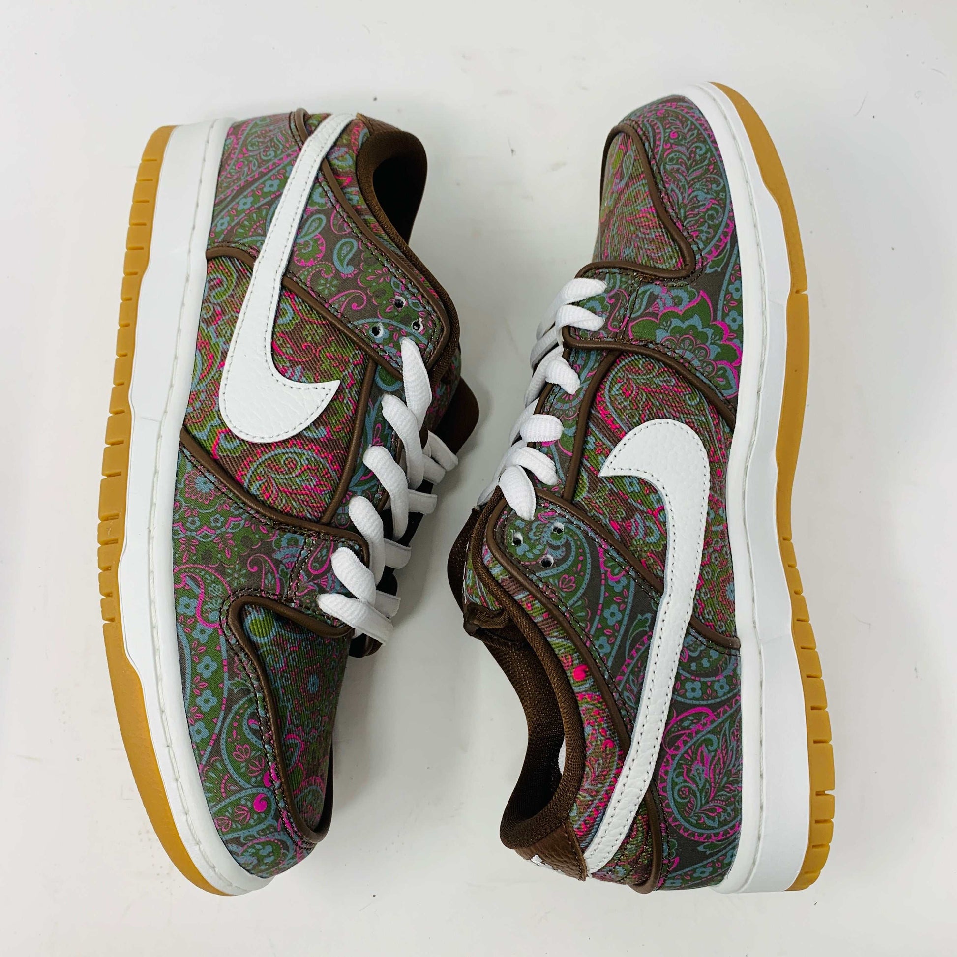 Nike SB Dunk Low Paisley Brown sneakers with paisley pattern and brown accents, white swoosh, gum sole, and extra brown laces.