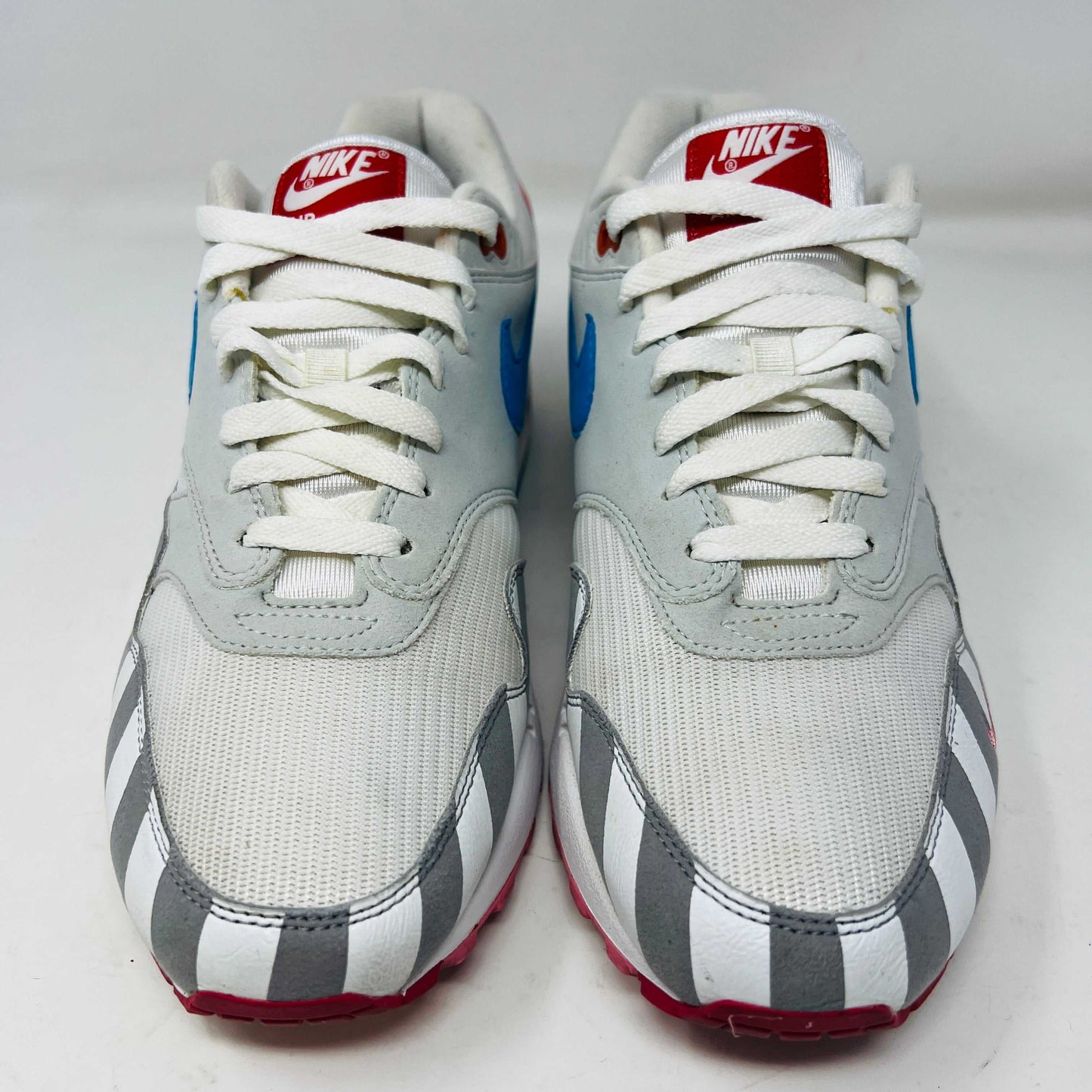 A Nike Air Max 1 Parra (2018) sneaker with clean uppers displaying stripes and polka dots sits on a box. The size 9.5 shoe features a blue swoosh and red, white, black accents, with visible original and discounted price tags ensuring authenticity.