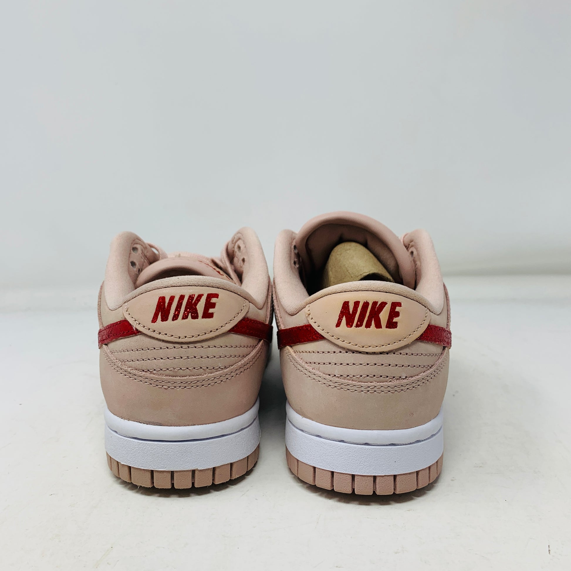 Displayed against a plain white background, the Nike Dunk Low PRM Pink Oxford (W) (Valentines Day CUSTOM) sneakers feature red swooshes, a white midsole, and pink outsole.