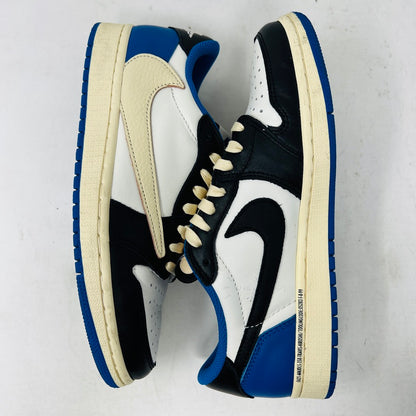 The Jordan 1 Retro Low OG SP Fragment x Travis Scott features a cream and black upper, blue heel and collar, and a cream sole with a signature swoosh design. Displayed against a plain backdrop without a box, it includes extra laces for versatility.