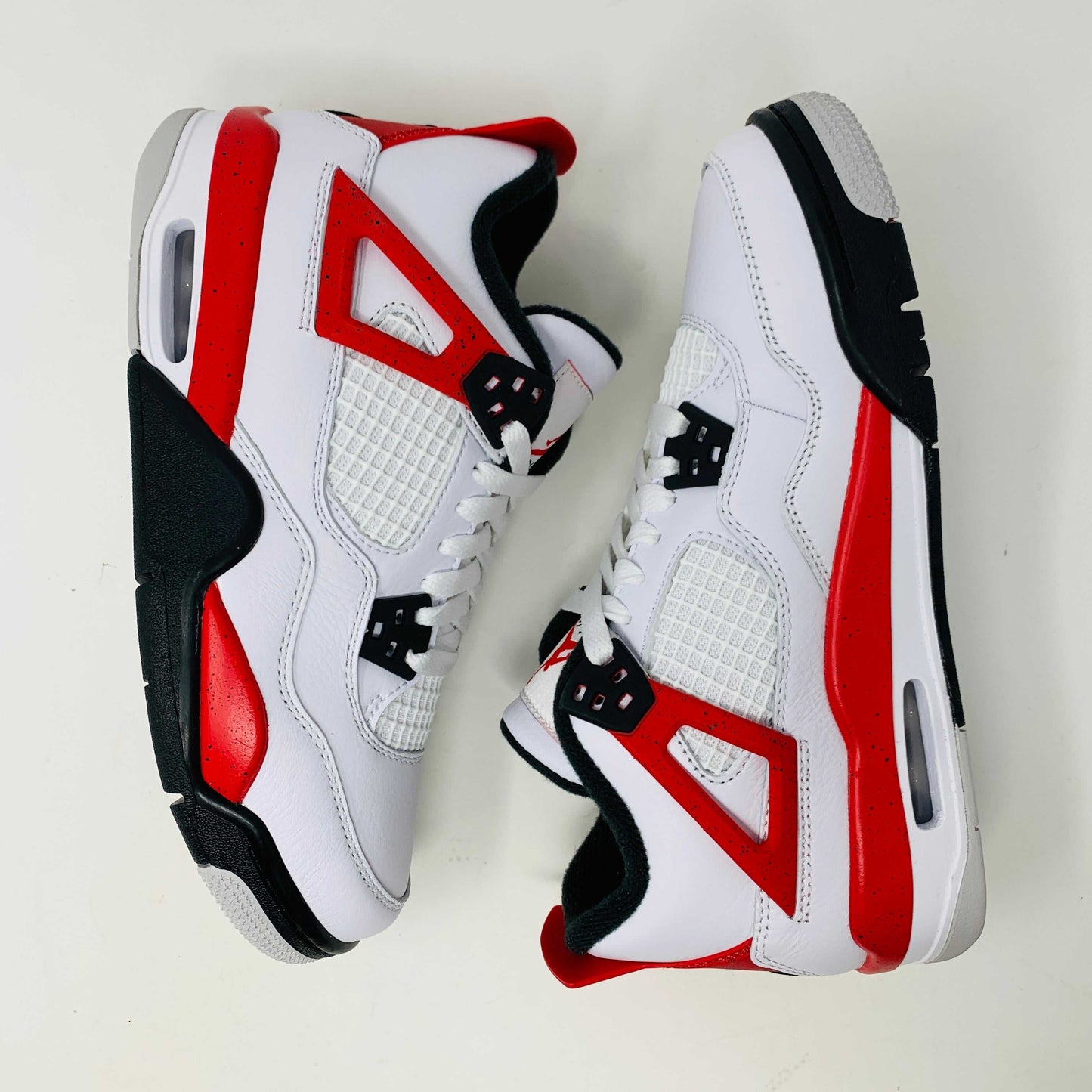 Jordan 4 Retro Red Cement GS sneakers featuring bold red colorway with cement grey accents.