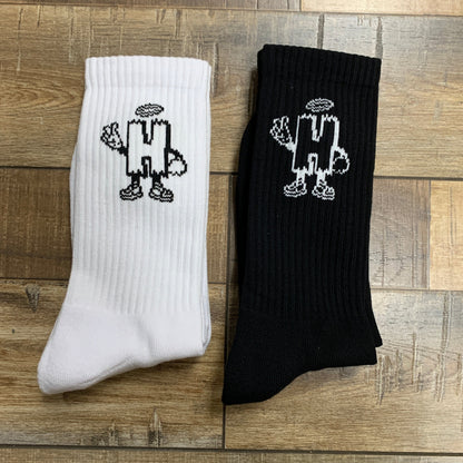 Holy Ground Socks in black and white with unique design on wooden floor.