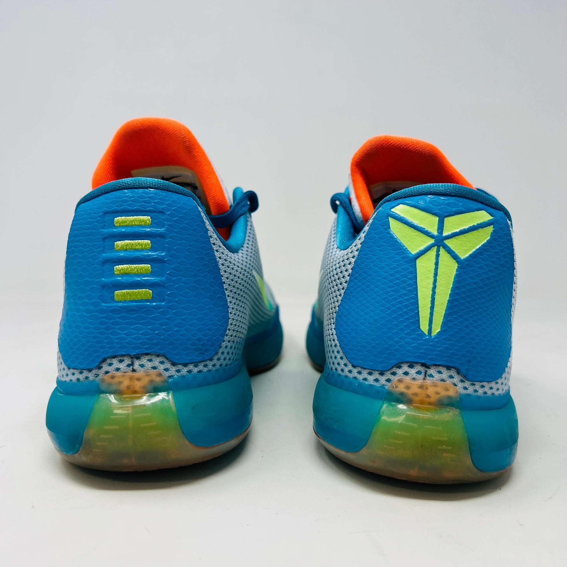 The Kobe 10 GS High Dive from Nike, in size 7Y, is on display with a blue upper, gradient yellow-green Swoosh, orange lining, and a multicolored sole. Its resting on its black box and shows normal wear.