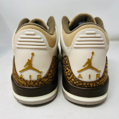 The Jordan 3 Retro Palomino, from the 2023 collection, features clean beige and brown uppers, textured brown accents, white laces, and a white midsole with a visible air unit. Its paired with a unique green and gray patterned replacement box.