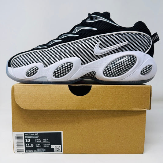 Nike NOCTA Glide Drake Black sneaker in good condition with clean uppers, displayed on a cardboard box.