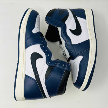 A brand new Jordan 1 Retro High OG Midnight Navy high-top sneaker, featuring navy blue, white, and black colors with the iconic swoosh and Air Jordan logo, displayed on a matching shoe box.