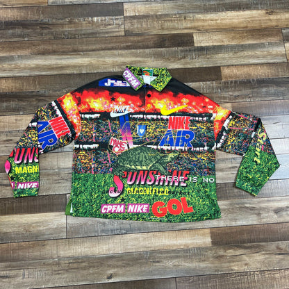 Nike x Cactus Plant Flea Market Longsleeve Polo Multicolor with vibrant graphics and logos on wood floor.