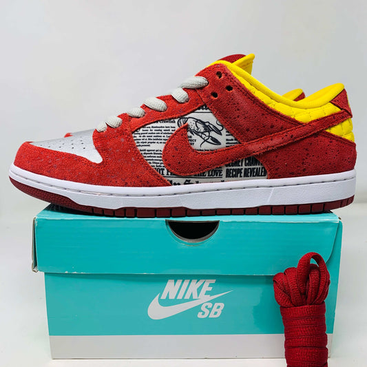 Nike SB Dunk Low Rukus Crawfish sneaker with red and orange textured upper, Nike SB and Rukus logos, displayed on a box.