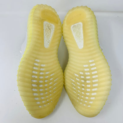 The image displays the treads and texture of light yellow Yeezy Boost 350 V2 Cream sneaker soles from an overhead view, set against a plain white background.