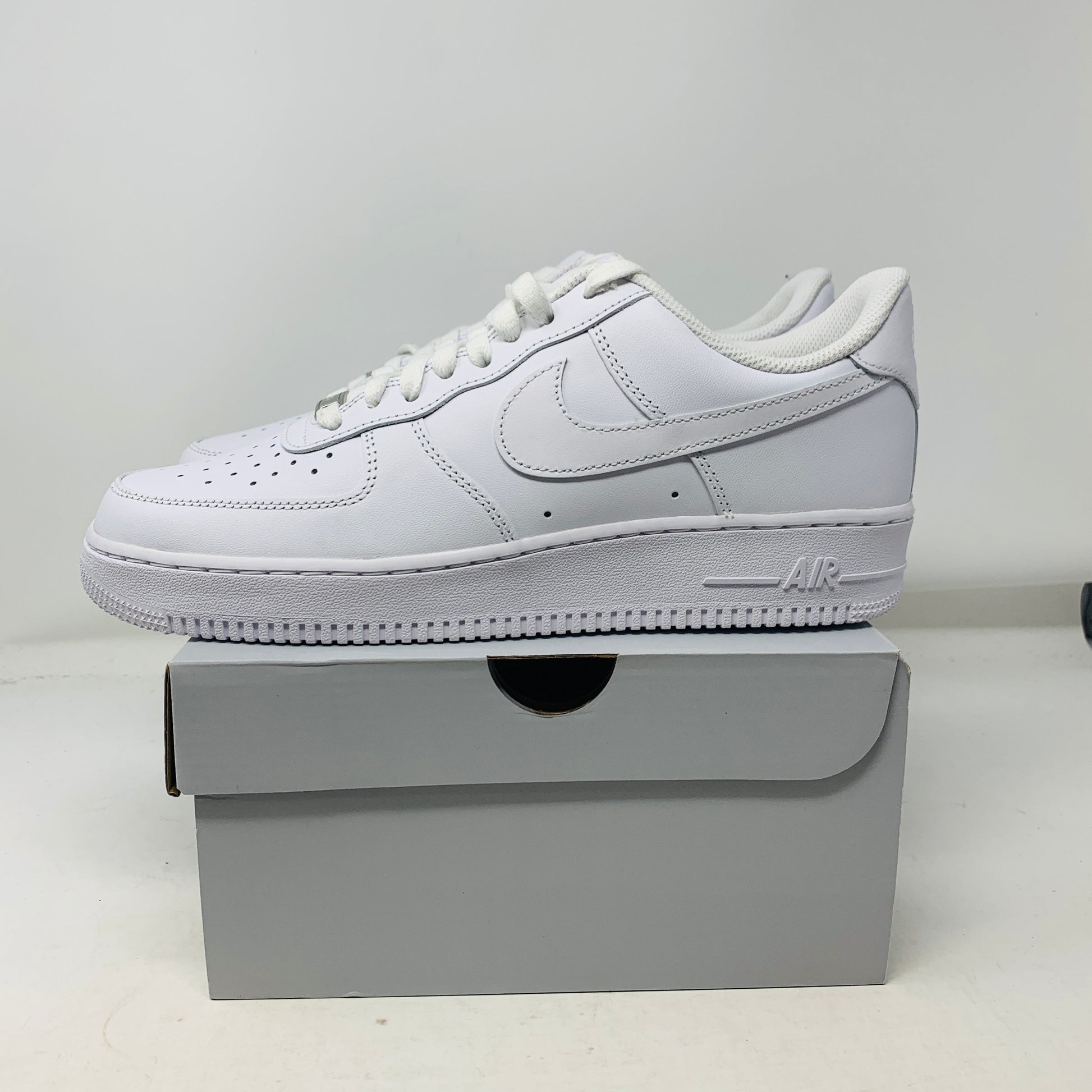 Nike Air Force 1 Low Triple White sneaker on box, brand new, 2023 edition.