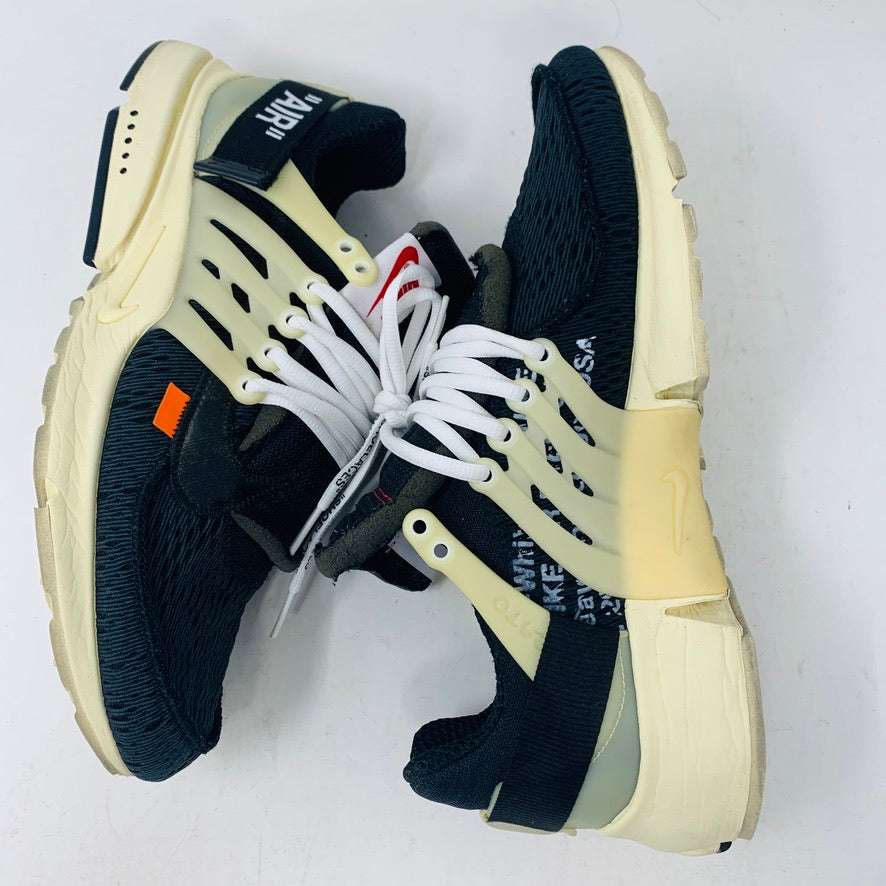 A pair of authentic Nike Air Presto Off-White sneakers featuring black uppers, cream soles, and white laces. They showcase a unique design with a red tag and orange side accents against a plain white backdrop.