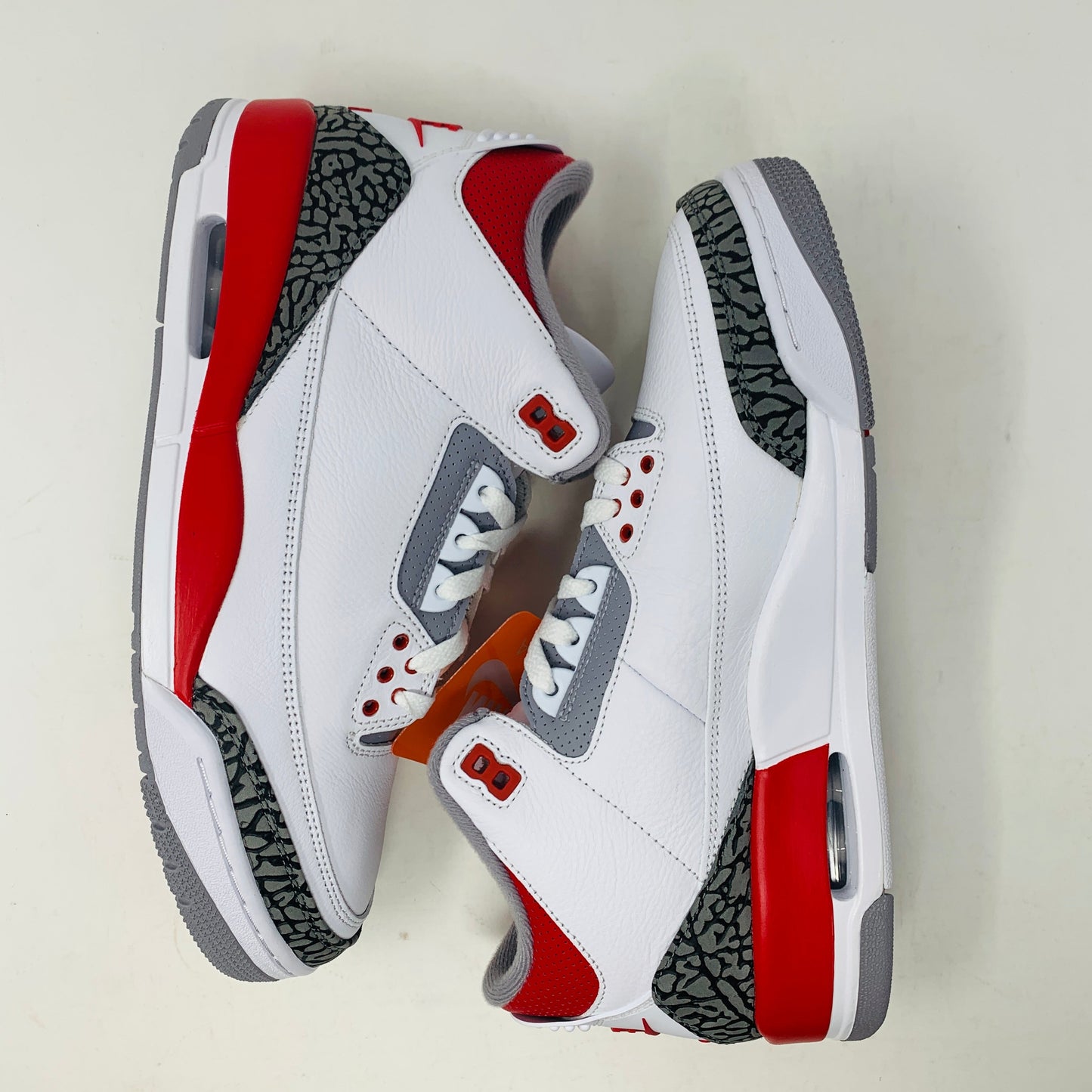 Jordan 3 Fire Red 2022 sneaker with white leather upper, red accents, and elephant print detailing.