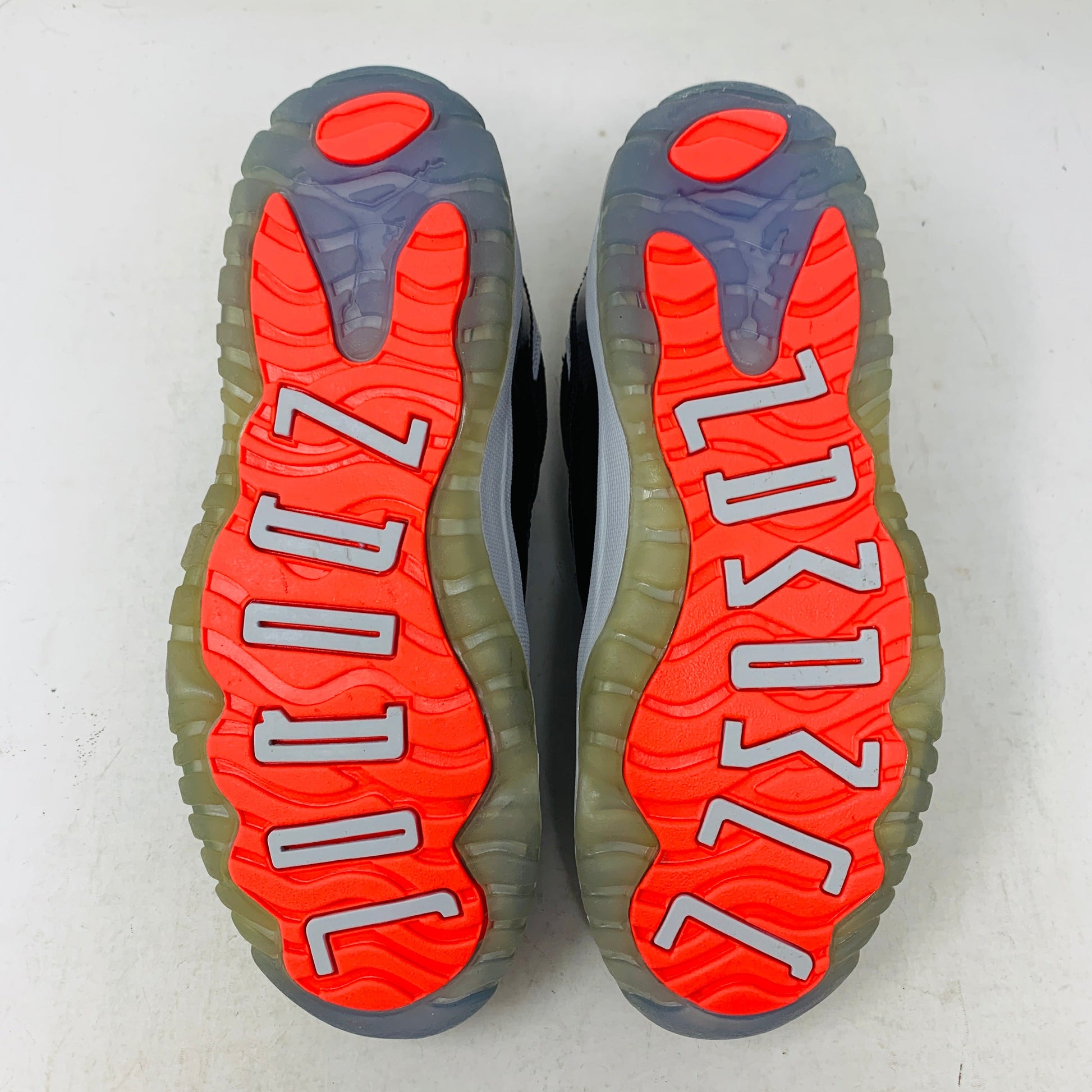 Outsole view of Jordan 11 Retro Low Infrared PS sneakers showing infrared and grey color pattern.