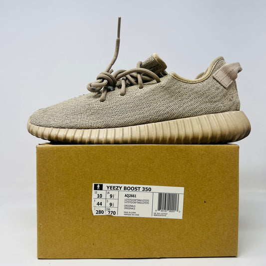 Adidas Yeezy Boost 350 Oxford Tan sneakers on a matching box with size and model details. These authentic shoes have a knitted texture, thick ribbed sole, clean uppers, and loosely tied laces.