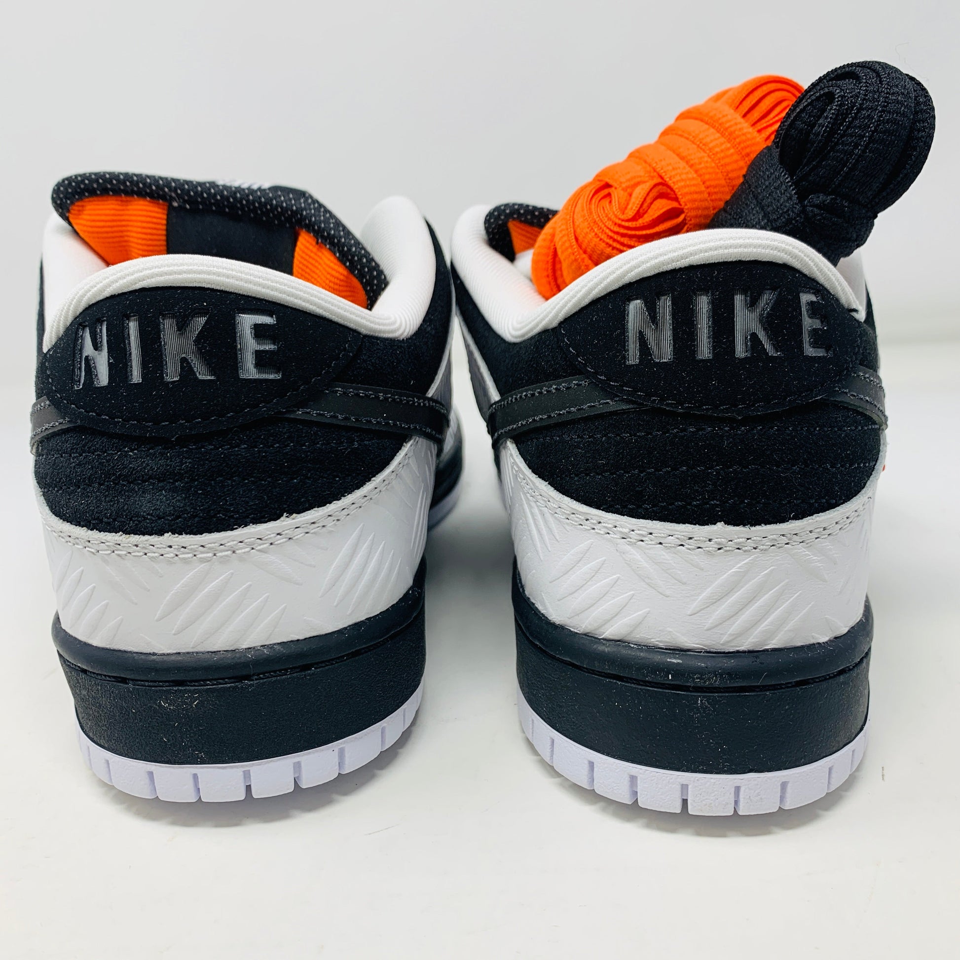 Nike SB Dunk Low TIGHTBOOTH sneakers with orange and black laces, rear view.