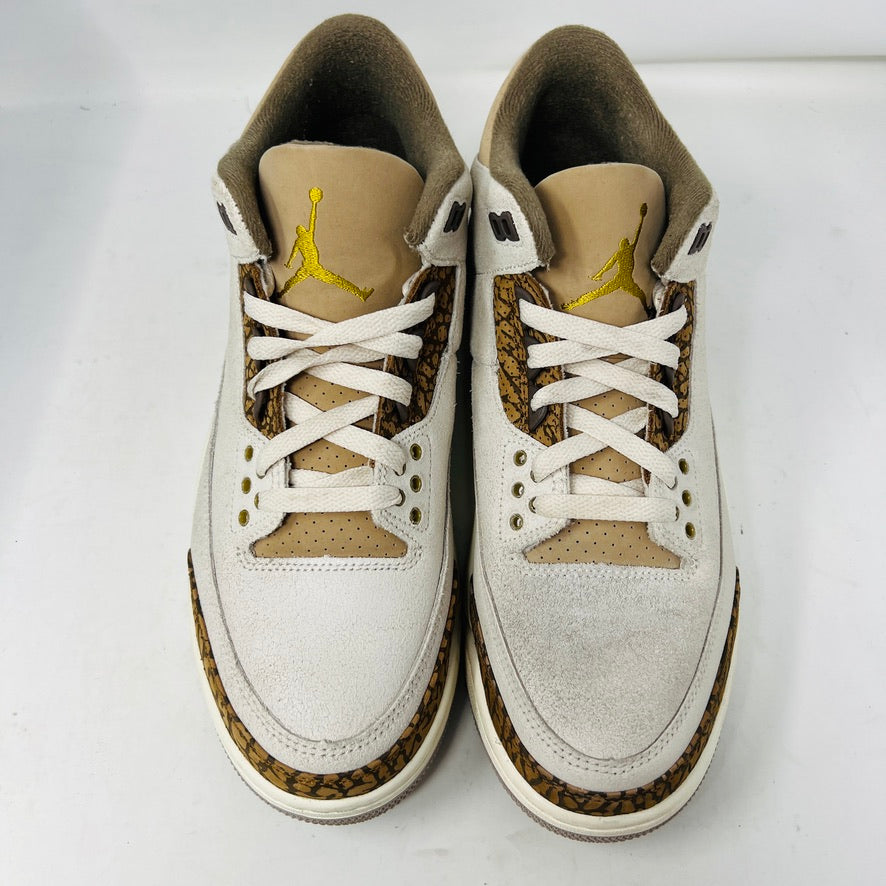 The Jordan 3 Retro Palomino, from the 2023 collection, features clean beige and brown uppers, textured brown accents, white laces, and a white midsole with a visible air unit. Its paired with a unique green and gray patterned replacement box.