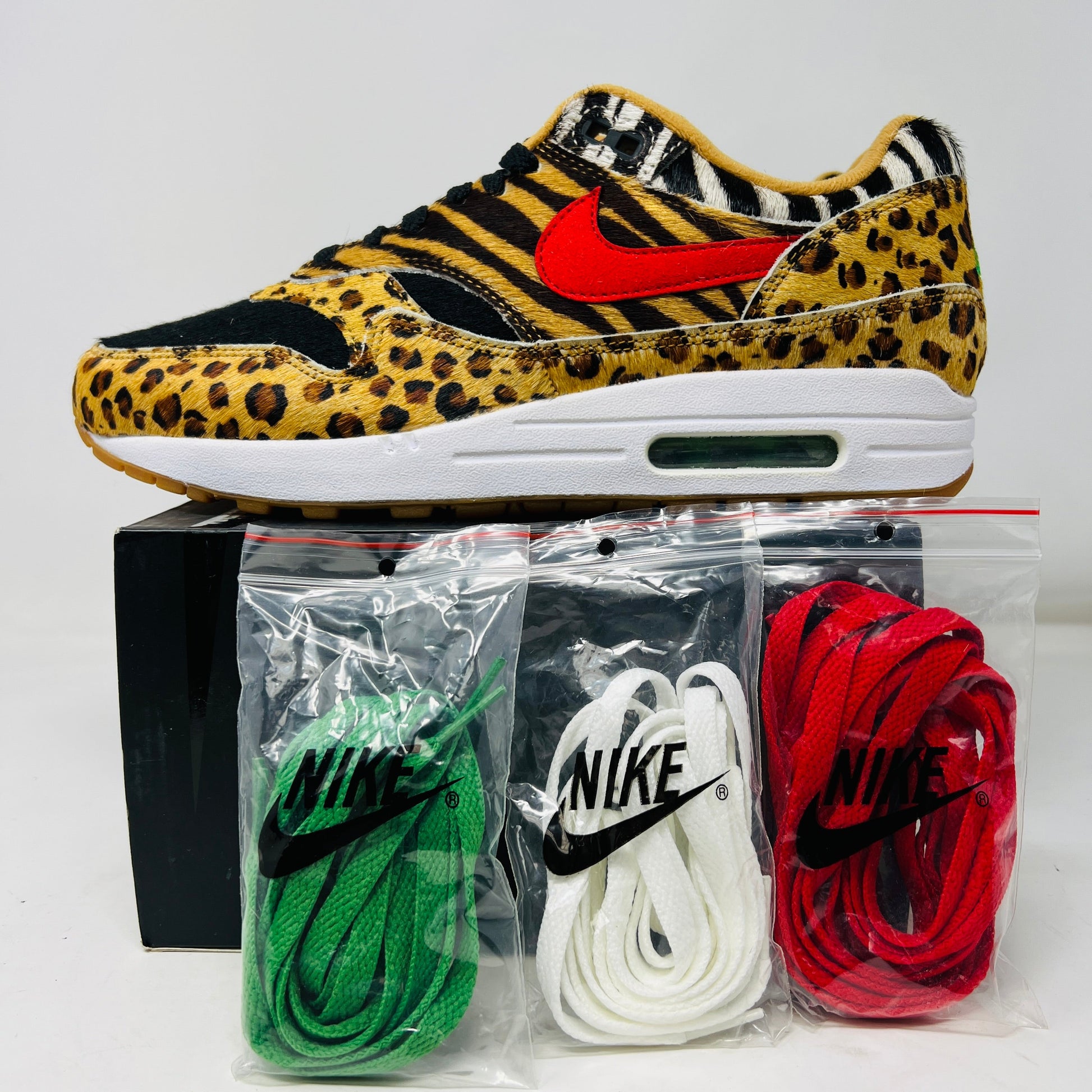 Nike Air Max 1 Atmos Animal Pack 2.0 sneakers with red, green, and white laces, brand new on a shoe box.