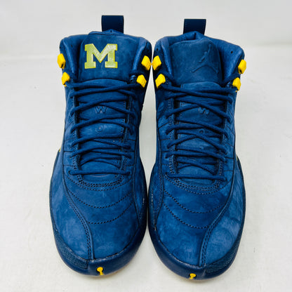 The Jordan 12 Retro Michigan is a blue high-top sneaker with yellow accents from Jordans 2018 Shoes collection. It features a textured surface, stitching details, and a visible Jumpman label. The dark blue sole highlights its vibrant design against a white background.